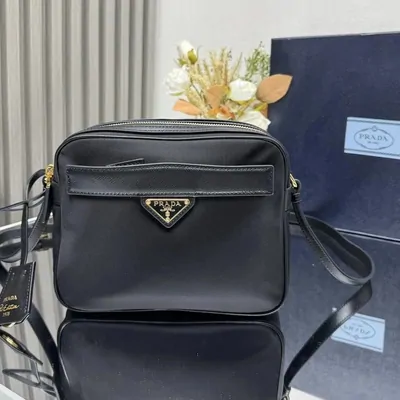 Black camera-style bag with a triangular logo plaque