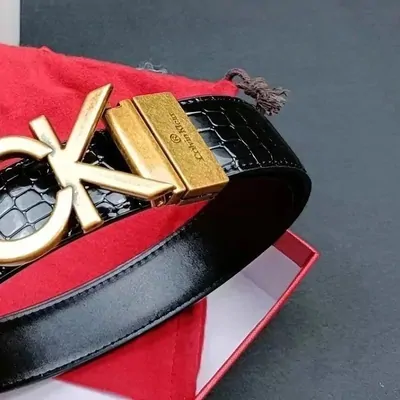 Black textured belt with a gold-tone buckle resting on a red box