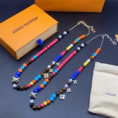 Beaded necklace in bright colours beside an orange box