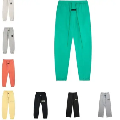 Relaxed sweatpants in green, orange and pale yellow on hangers