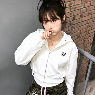 Model in a white zip hoodie and dark trousers